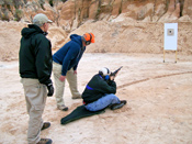 Now the coach instructs the pupil to shoot a rifle from the sitting position.